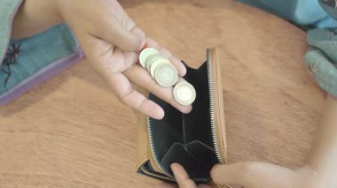 Bir kafede otururken birisi cüzdanının içindeki paraları kontrol ediyor..