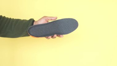 Kişi deseni ve tasarımını vurgularken bir ayakkabı tabanı gösterir.