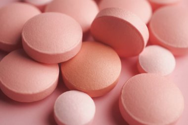 Çeşitli pembe tabletler yakın sıralanmış, şekillerini ve dokularını vurguluyorlar..