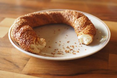 Lezzetli susamlı ekmek tabakta duruyor, tadını çıkarmaktan kalan kırıntılar..