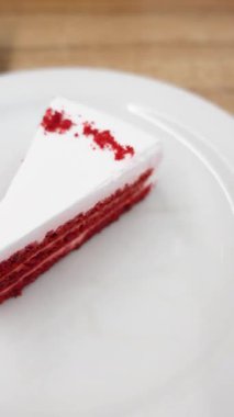 Krem peynirli bir dilim kırmızı kadife kek tabakta servis edilir..