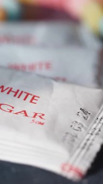Canlı renklere sahip bir masada gösterilen şeker paketlerinin yakın görüntüsü.
