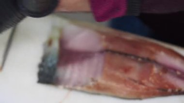 Bir uzman, güneşli bir sahil mutfağında ustalıkla balık avlıyor..