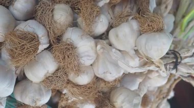 Kökleri olan taze sarımsak soğanları hareketli bir pazarda istiflenir..