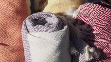 Dokuma dokuma ürünlerinin canlı ruloları açık hava pazarında sergileniyor..