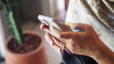 Bir kadın kapalı bir ortamda akıllı telefonuyla iletişim kurar..