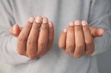 İki açık el, davetkar bir şekilde rahatlamış parmaklarıyla hareket eder..