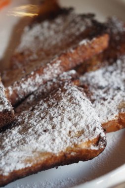 Pudra şekerle kaplanmış lezzetli ekmek dilimleri tadını çıkarmaya hazır..