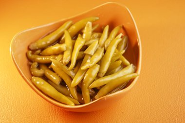 Parlak sarı-yeşil salamura biber bir kasede dizilmiş..