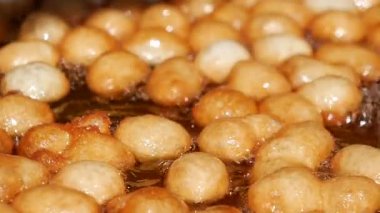 Küçük yuvarlak abur cuburlar markette kızgın yağda kızarıyor..