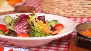 Taze sebze ve lezzetlerle dolu canlı bir salatanın tadını çıkarıyorum..