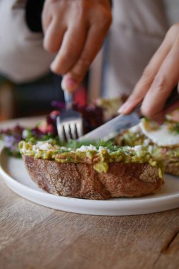 Yanında salata ile lezzetli bir avokado tostu dilimliyorum..