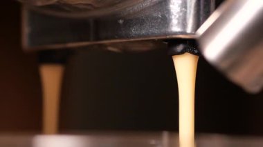 Kahve makinesinden taze espresso fışkıran bir kafede fincana dökülüyor..