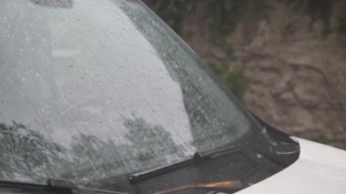 Fırtınalı bir öğleden sonra yağmur damlaları arabaların ön camlarından aşağı süzülür..
