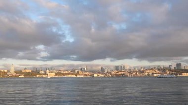 İstanbul 'un güzel silueti gün batımında bulutlarla birlikte su boyunca uzanır..