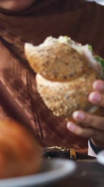 Bir insan çeşitli malzemelerle taze bir sandviç yapmaktan hoşlanır..