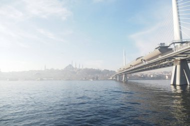 Sabahın erken saatlerinde Altın Boynuz üzerindeki modern bir köprüyü aydınlatır..