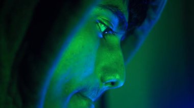 Kapüşonlu genç gece bilgisayar başında çalışıyor veri çalıyor, siber suç işliyor. .