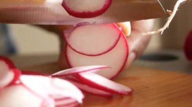 Sağlıklı bir salata karışımı için tahta tahtada taze turpları doğramak..