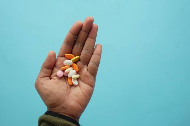 Tabletlerin farklı renkleri ve şekilleri açık bir elde gösterilir.