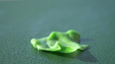 Parlak yeşil sakız dokulu yeşil bir yüzeyde duruyor..