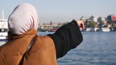Rıhtım binalarında geleneksel jestler yapan bir kadın..