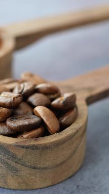 Ahşap kepçeyle ölçülen kavrulmuş kahve çekirdeklerinin tadını çıkarın..