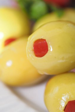 Kırmızı pimento dolgulu sarı zeytin yakın plan, çekici bir şekilde dizilmiş..
