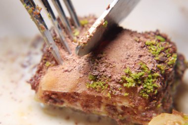 Çatalla kesilen baklava, hamur işi ve fındık katmanlarını ortaya çıkarıyor..