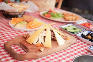 Peynir tabağında konuklar için çeşitli peynirler ve taze sebzeler vurgulanıyor.