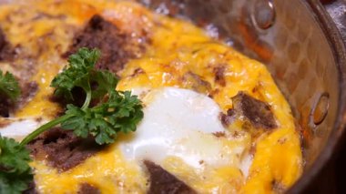 Yumurta, peynir ve sığır eti içeren lezzetli bir kahvaltı güvecinin tadını çıkarın..