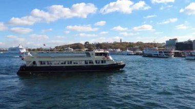 İstanbul 'un canlı sularında güneşli bir gökyüzünün altında seyir gemileri süzülüyor..