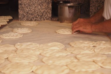 Eller, sıcak bir mutfakta taze hazırlanmış hamur üzerinde karmaşık desenler yaratır..