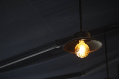 Sıcak ışık, sıradan bir kafe atmosferinde rahat bir köşeyi aydınlatır..