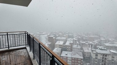 Kar taneleri kışın gökyüzünde kaybolan bir şehir silueti gibi havayı dolduruyor..