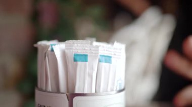 Şeker paketleri kahve masasının üzerinde bir fincanda durur..