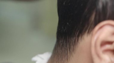 Bir berber ayrıntılı detaylara odaklanırken kısa bir stil oluşturur.