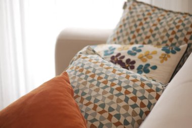 Rengarenk desenli yumuşak yastıklar kanepeye düzgünce yerleştirilir..