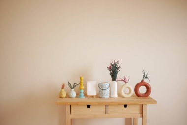 Renkli vazolar ve basit bitkiler masanın üzerinde şık bir görüntü oluşturur..