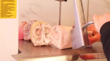 Bir kasap günün erken saatlerinde yerel bir dükkanda ustaca taze et doğruyor..