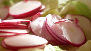 Canlı turp dilimleri taze bir yemeğin gelişmesi için gevrek marulların üzerinde dinleniyor..