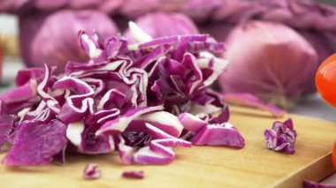 Sağlıklı bir yemek hazırlamak için soğanlı canlı kırmızı lahana doğramak..