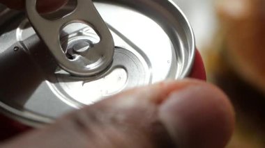 Sıradan bir ortamda soğuk bir içeceğin tadını çıkarmak için konserve açmak..