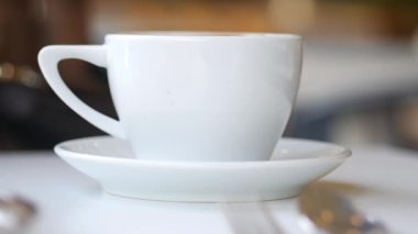 Kahve fincanı ve çay tabağı bir kafede masanın üzerinde duruyor..