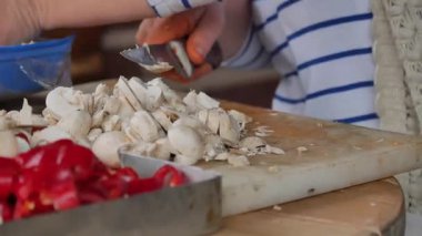 Katılımcılar mantar ve biber doğruyor, birlikte yemek pişirme becerileri öğreniyorlar..