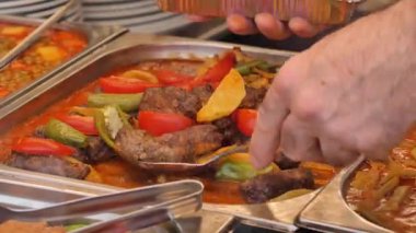 Lokantalar, açık hava pazarında çeşitli renkli yemeklerin tadını çıkarırlar..