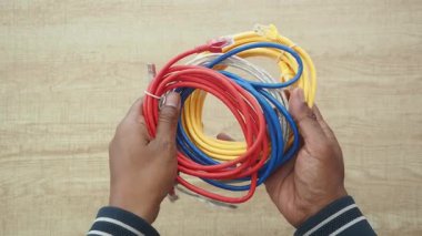 Eller gelecek bir kablo projesine hazır çeşitli renkli kabloları kavrıyor.