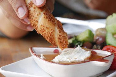  Türk simit ekmeği kremalı sosa batırılıyor .
