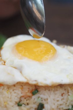 Bir kaşık, pirinçli yumurtanın üzerine sos serper..