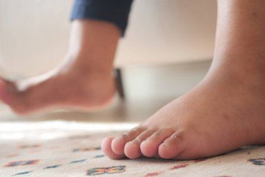 Bir çocuk, canlı bir halının üzerinde dinlenirken içeride uzanır..